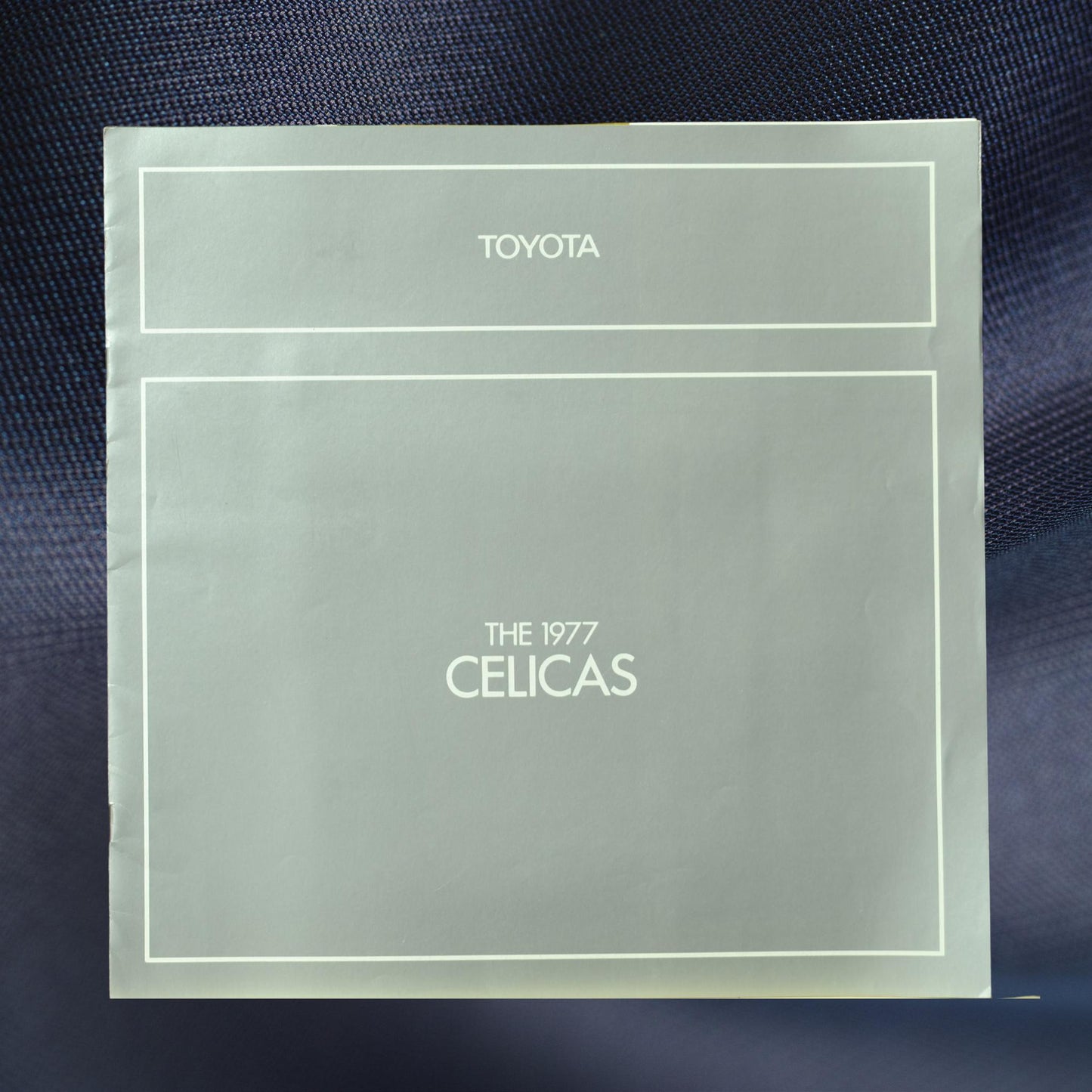 Front cover of the 1977 Toyota Celica dealer brochure, showcasing clean minimalist design in silver-gray with Toyota branding