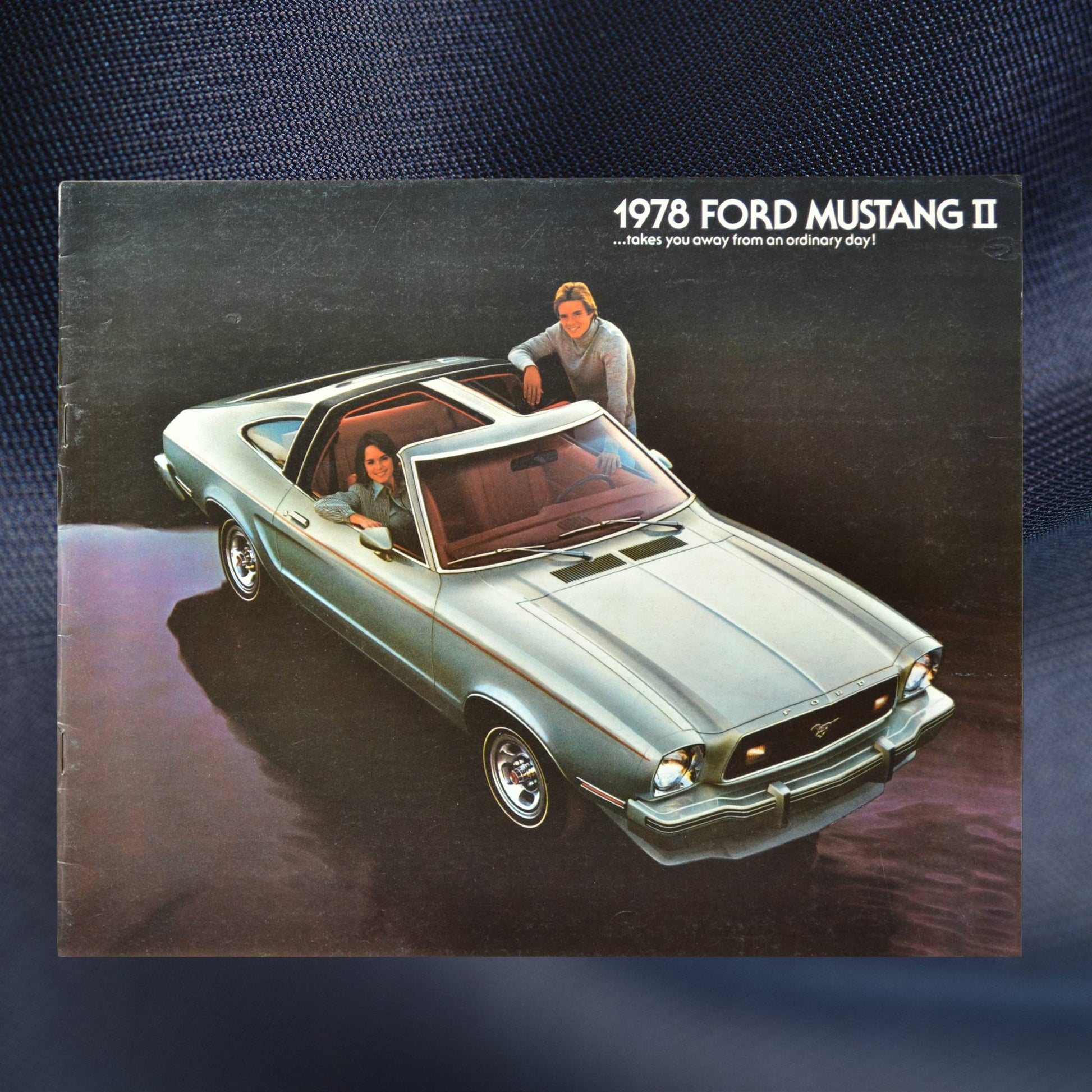 Front cover of the 1978 Ford Mustang II dealer brochure, featuring a green Mustang II with T-roof and two people inside.