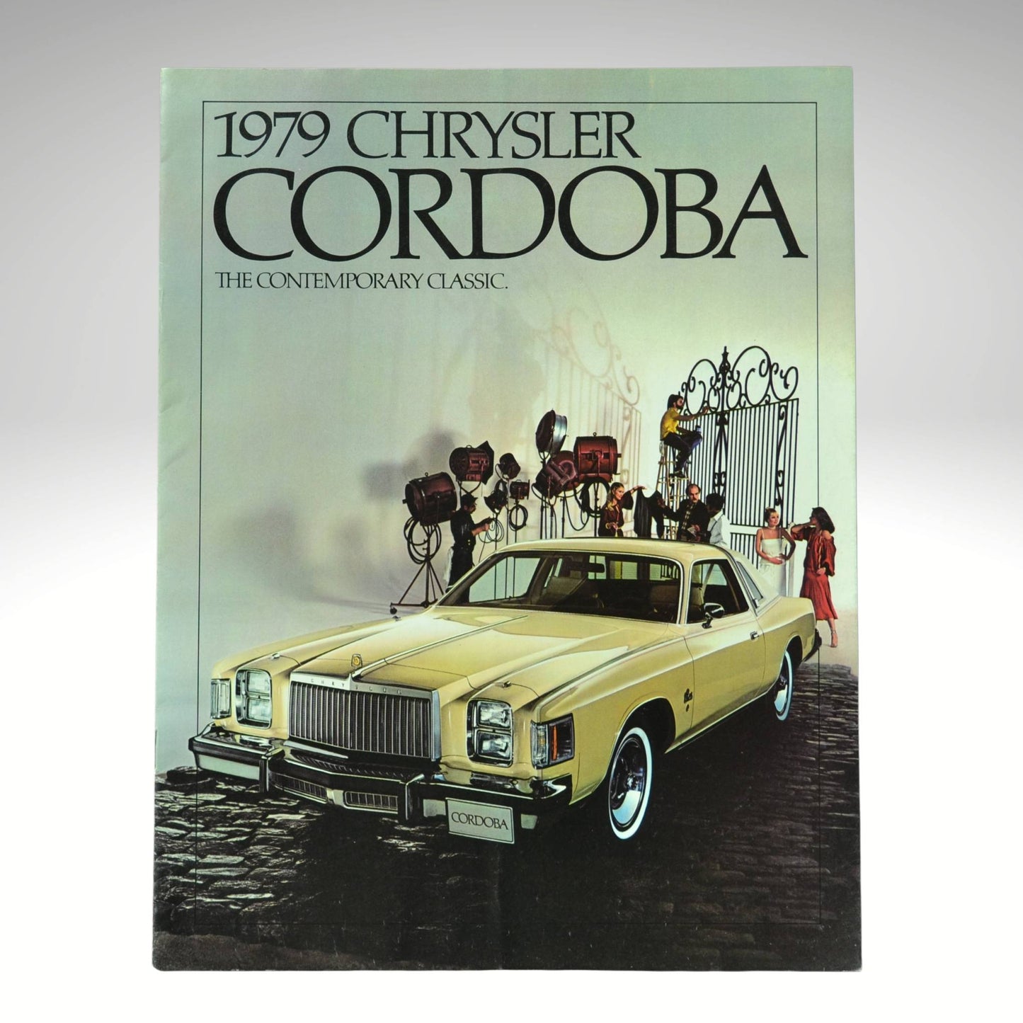1979 Chrysler Cordoba advertisement with a car and people at a gate.