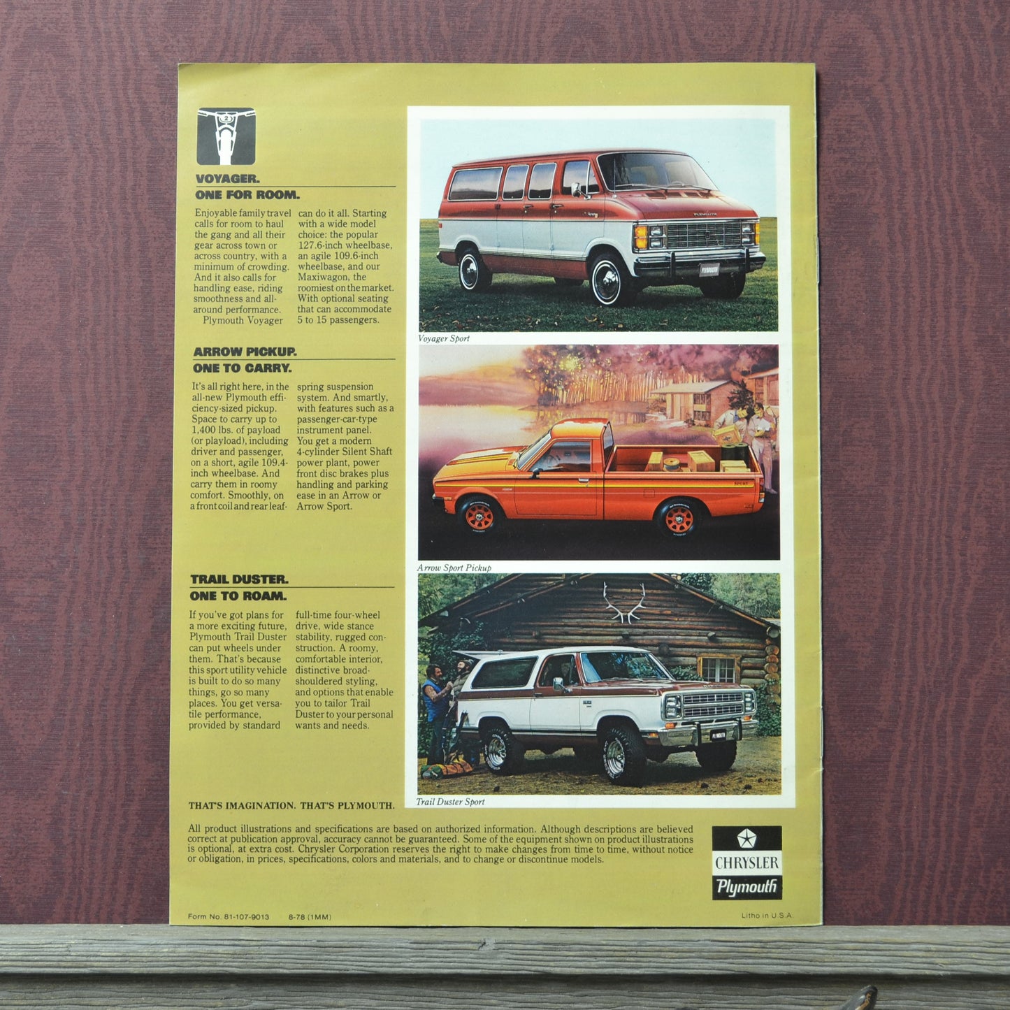 Vintage advertisement for Plymouth Voyager, Trail Duster, and Grand Voyager on a wooden surface.