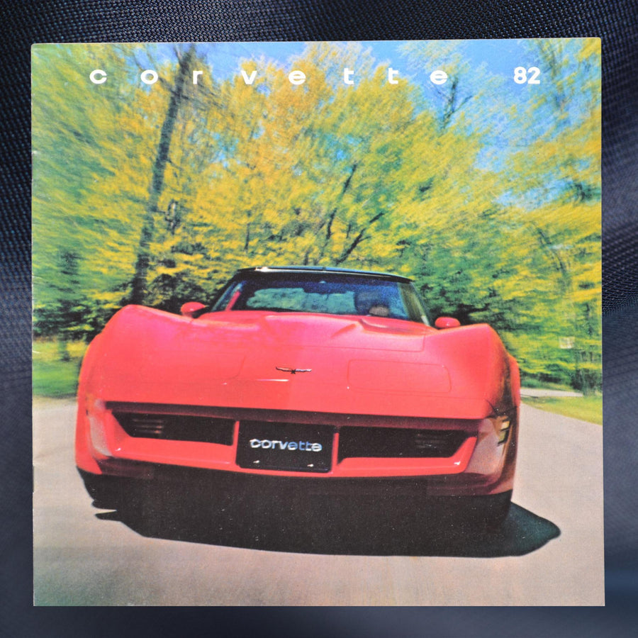 1982 Chevrolet Corvette brochure cover with a red Corvette driving on a scenic road.