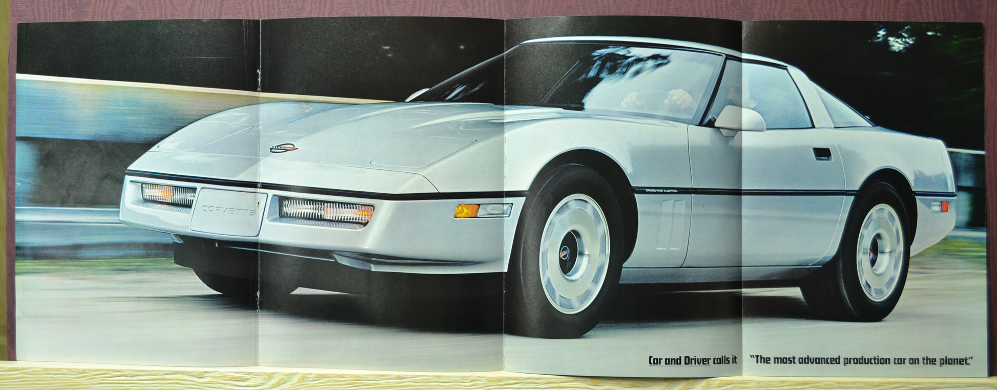 Fold-out poster of silver 1984 Chevrolet Corvette in motion – vintage trifold ad layout