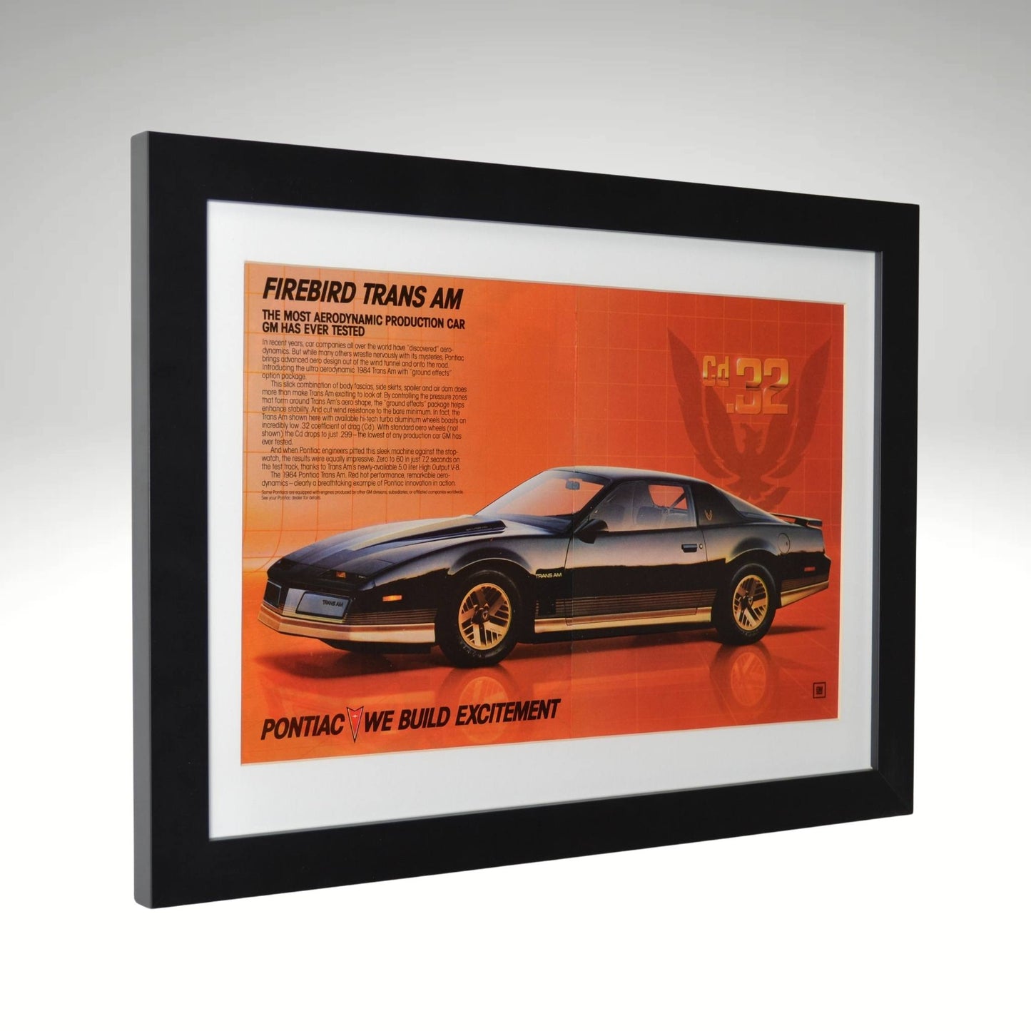 side view of black 1984 Pontiac Firebird Trans Am framed print ad featuring the Cd .32 aerodynamic design, Firebird emblem, and classic 80s Pontiac styling.