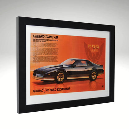 side view of black 1984 Pontiac Firebird Trans Am framed print ad featuring the Cd .32 aerodynamic design, Firebird emblem, and classic 80s Pontiac styling.