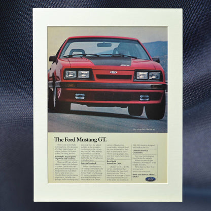 1985 Ford Mustang GT vintage print ad featuring the iconic Foxbody Mustang in red. Classic muscle car advertisement, perfect for garage decor and Mustang collectors.

