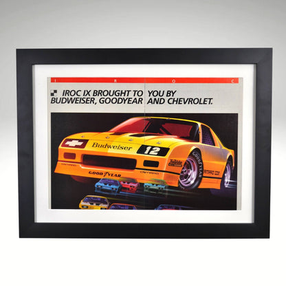 1986 Chevrolet IROC Camaro framed vintage print ad featuring the Budweiser-sponsored Z28 race car, Goodyear branding, and bold racing graphics.