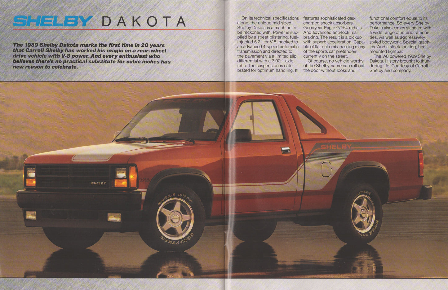 A vintage magazine-style page featuring a red and gray Shelby Dakota pickup truck with printed text columns above and below it, set against a reflective water-like surface.