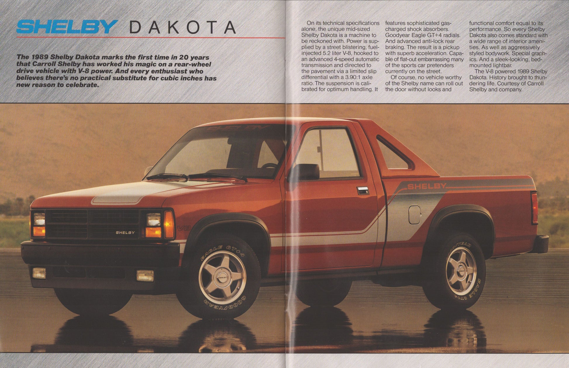 A vintage magazine-style page featuring a red and gray Shelby Dakota pickup truck with printed text columns above and below it, set against a reflective water-like surface.
