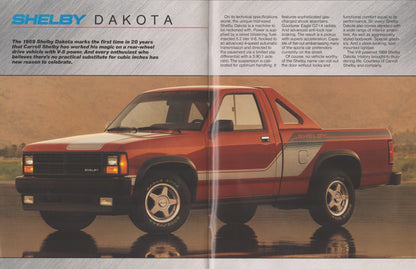 A vintage magazine-style page featuring a red and gray Shelby Dakota pickup truck with printed text columns above and below it, set against a reflective water-like surface.