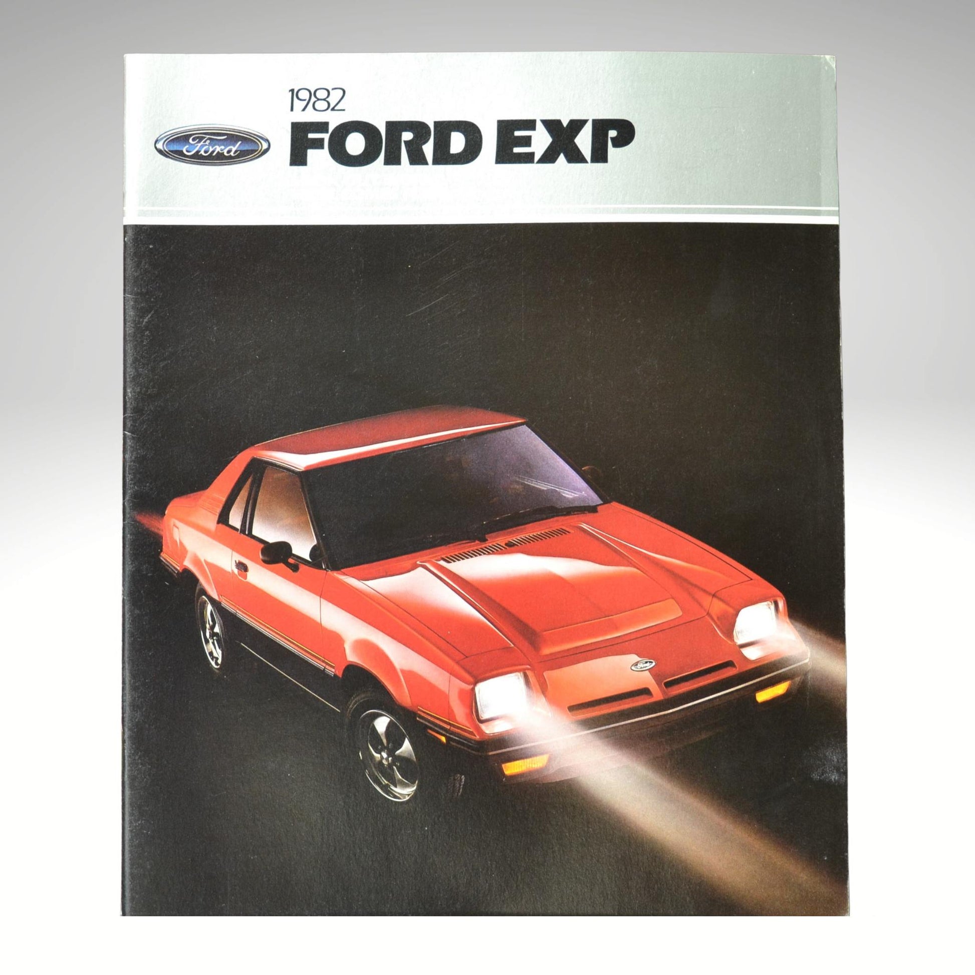 1982 Ford EXP brochure cover with a red car illustration on a gray background