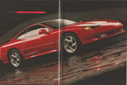 A vintage automotive magazine spread featuring a red Dodge Stealth R/T 1999 sports coupe on a wet reflective street, with 'DODGE STEALTH R/T 1999' printed at the top left.