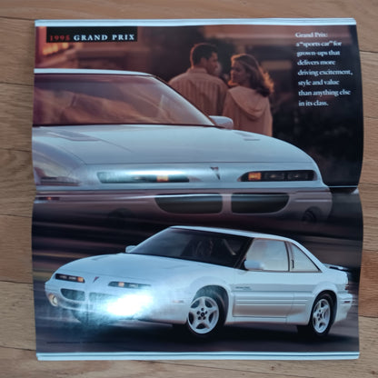 1985 Pontiac Grand Prix car brochure on a wooden surface
