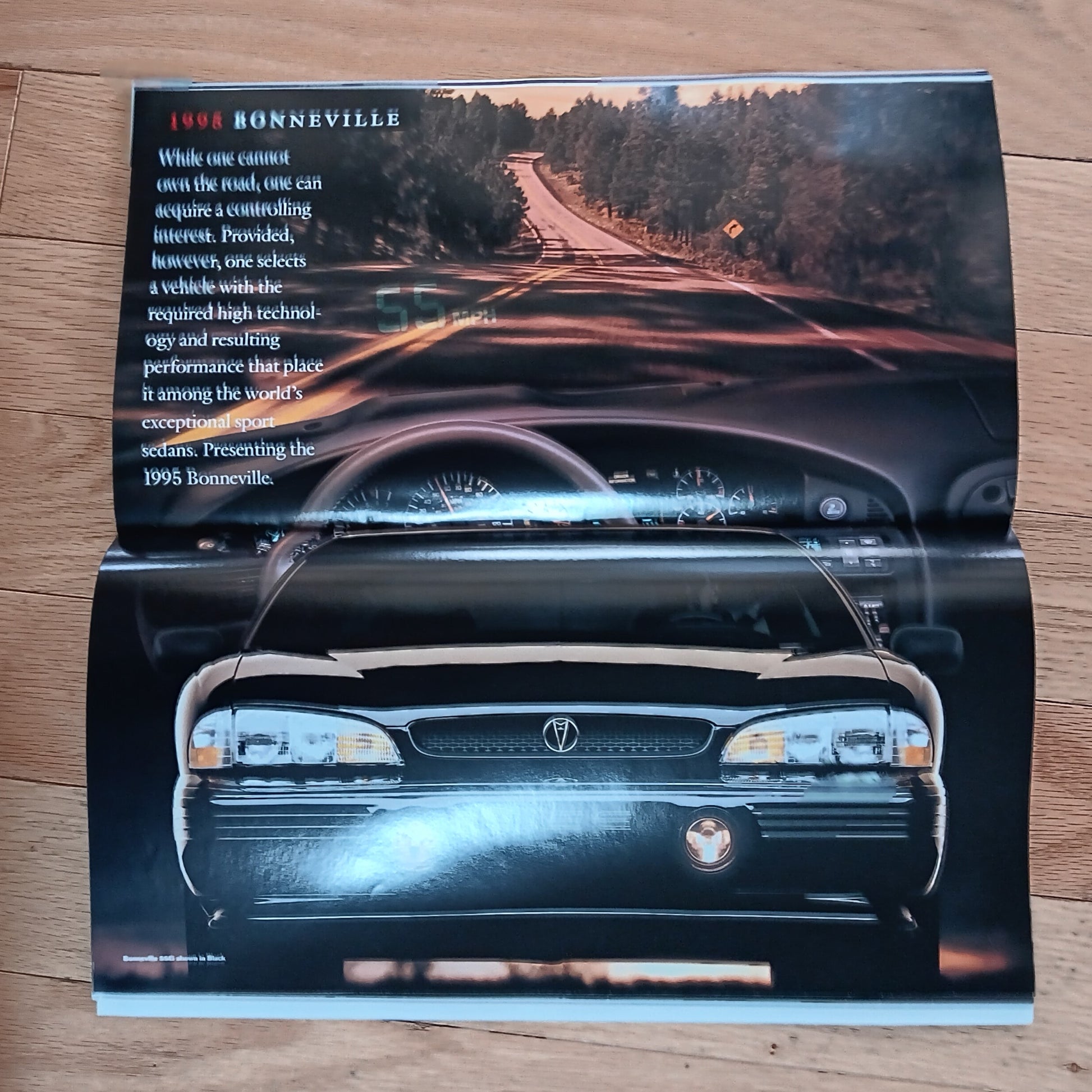 Car brochure for 1998 Bonneville on a wooden surface
