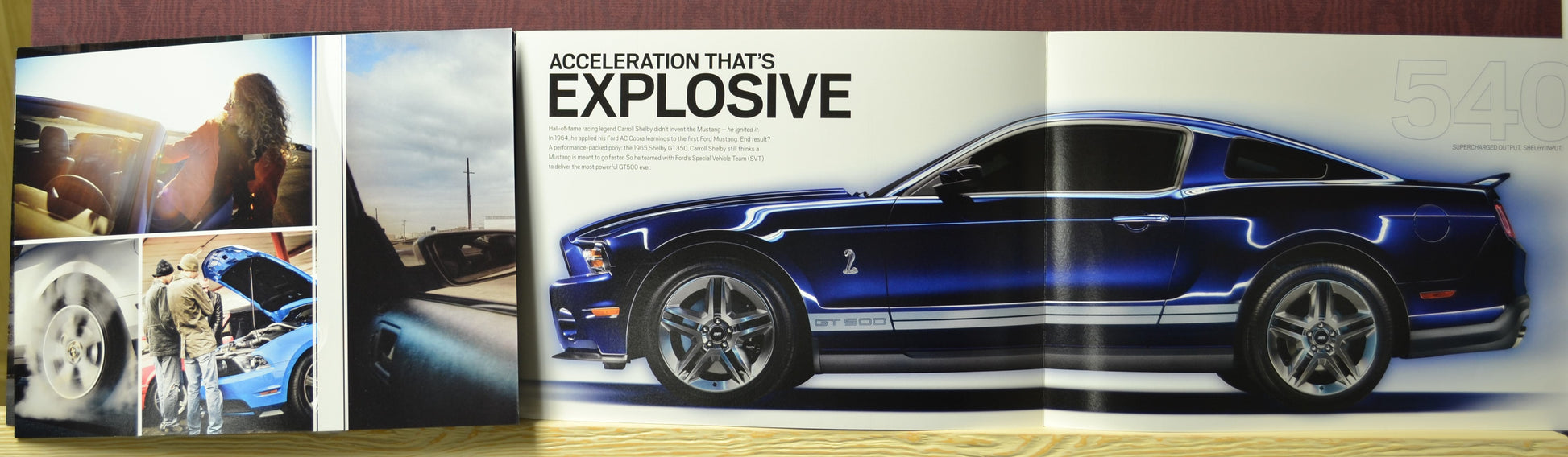 Side profile of blue 2010 Shelby GT500 Mustang with performance specs from vintage Ford catalog – supercharged 540 hp V8

