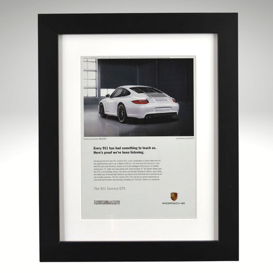 Framed Porsche 911 GTS advertisement with a white car on a gray background