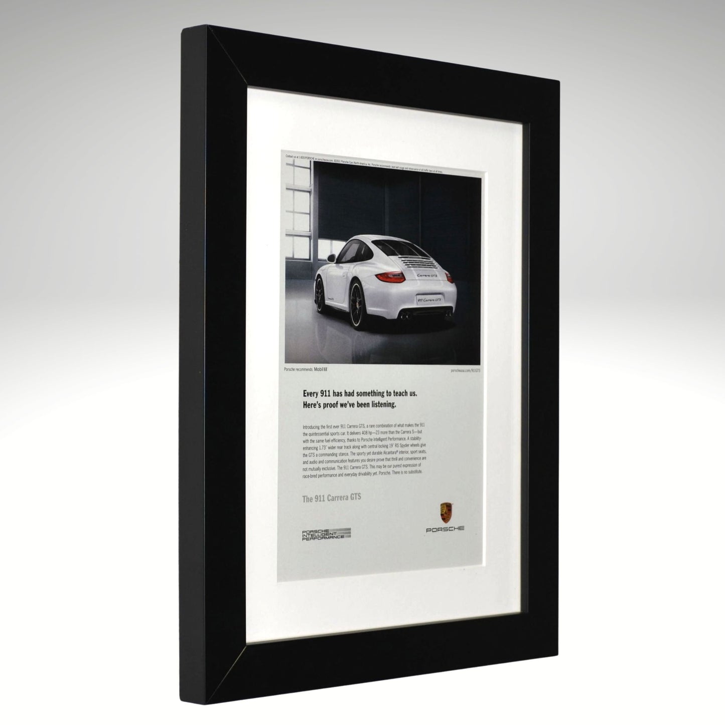 Framed advertisement of a white Porsche 911 GTS car on a gray background