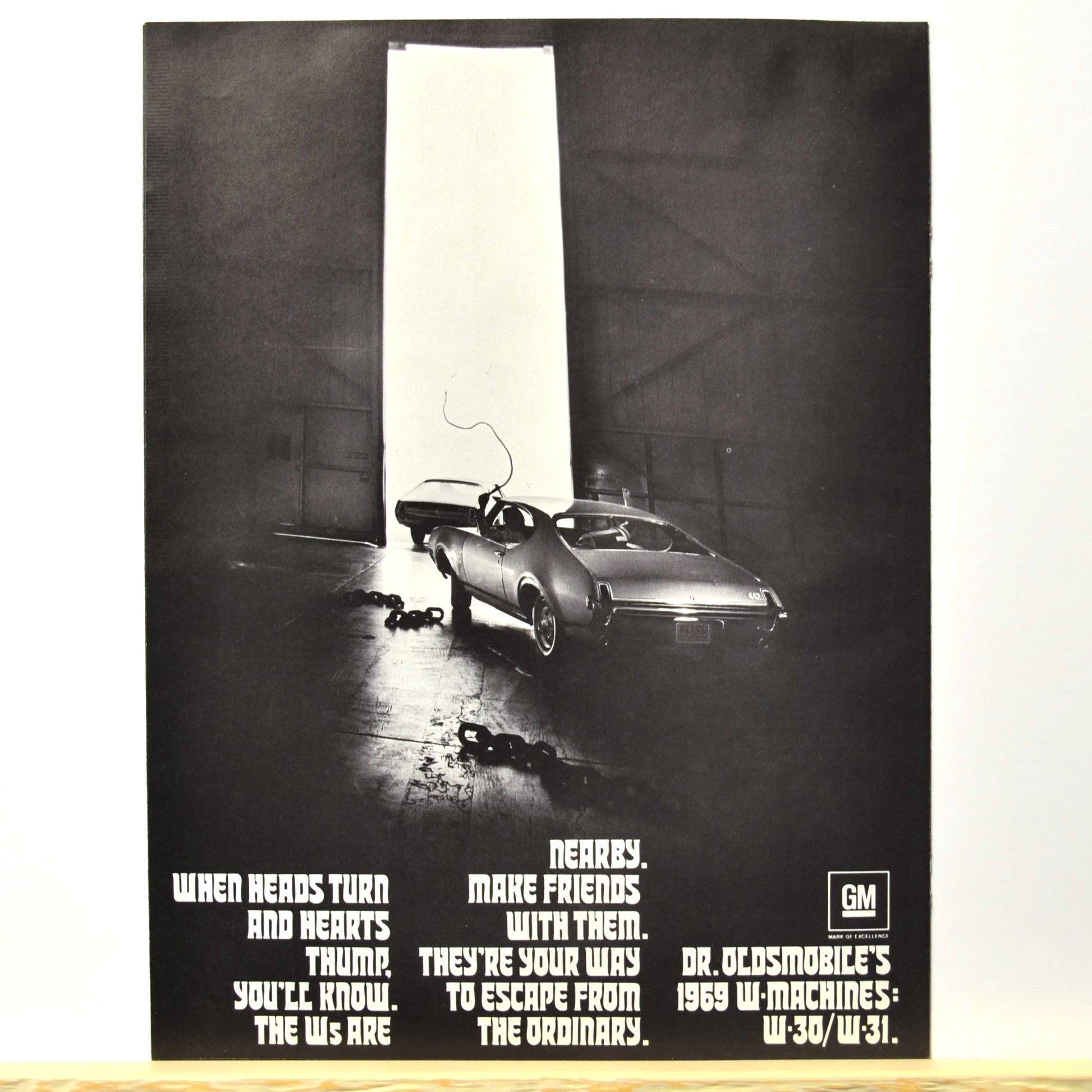 Back cover with 1969 W-Machine exiting garage, tagline “Escape from the ordinary”

