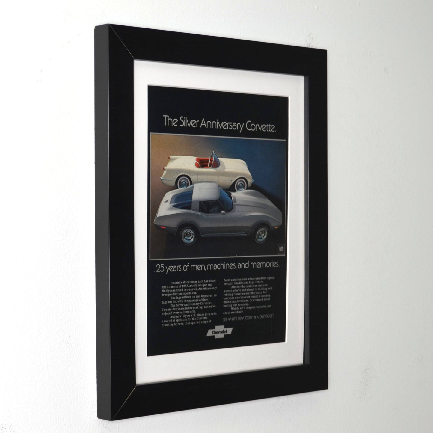Framed poster of a Silver Anniversary  1953 and 1978 Corvette on a white wall