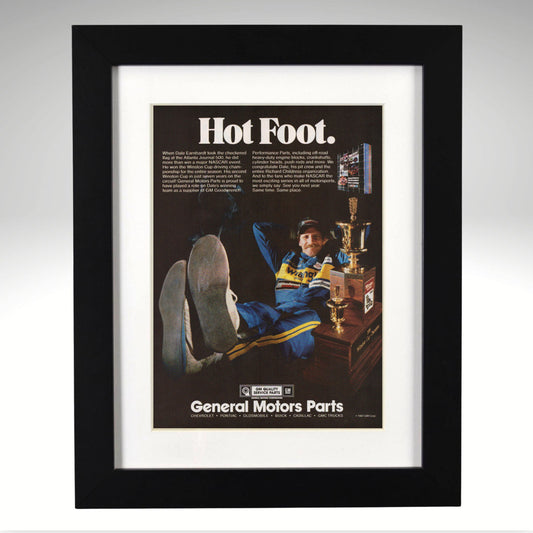 Framed advertisement for General Motors Parts with a Dale Earnhardt in a chair and text 'Hot Foot'.