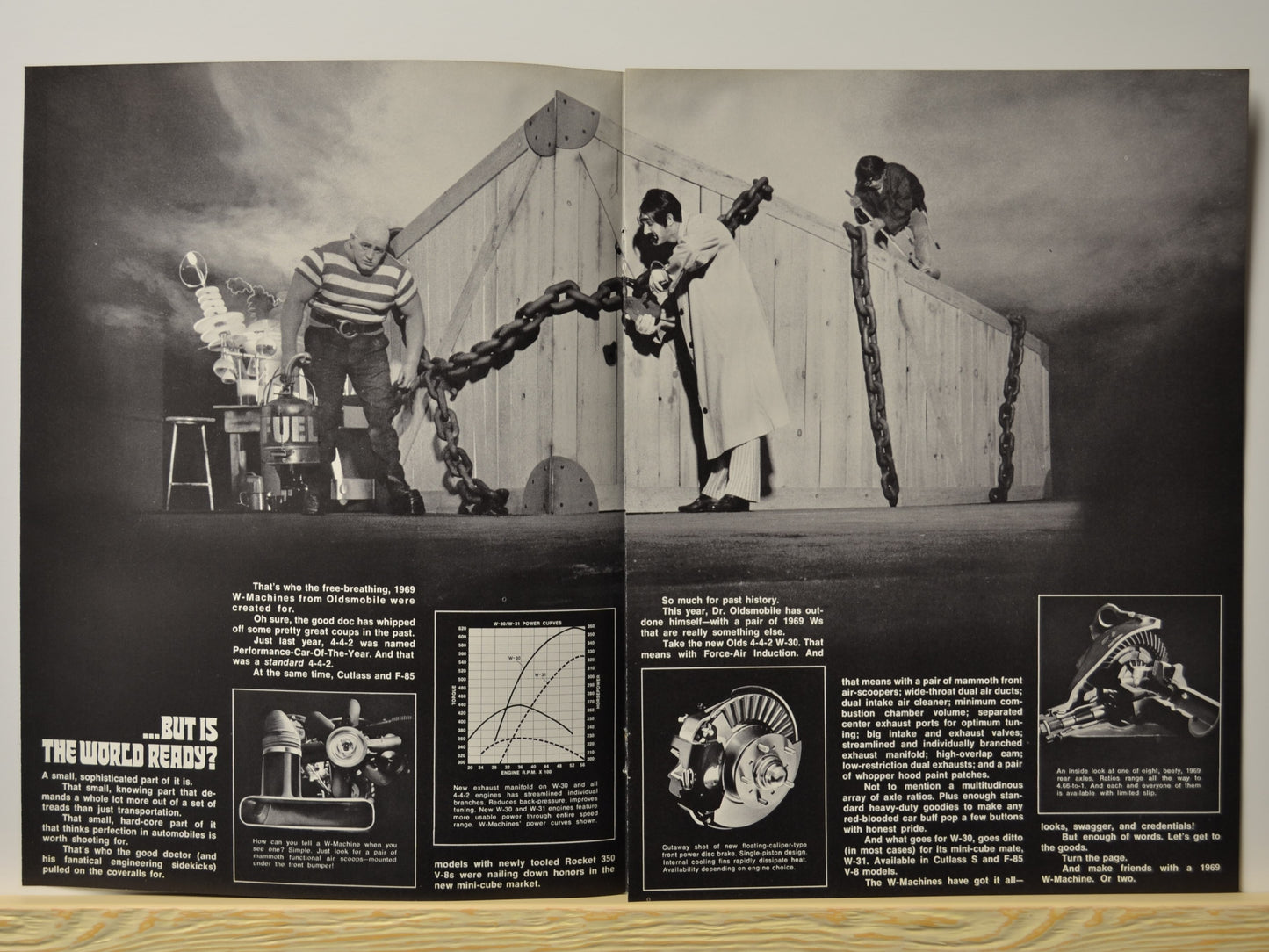 Double-page scene with crate and cast promoting W-Machine performance
