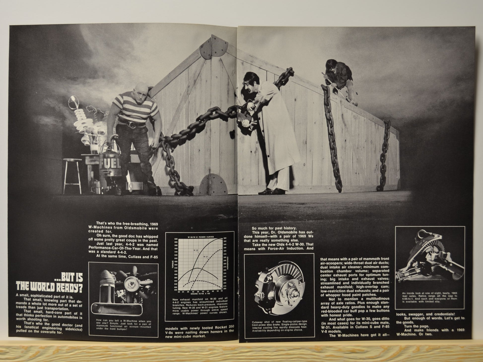 Double-page scene with crate and cast promoting W-Machine performance