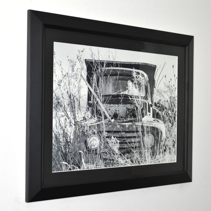Framed black and white photograph of a vintage ford truck in a field