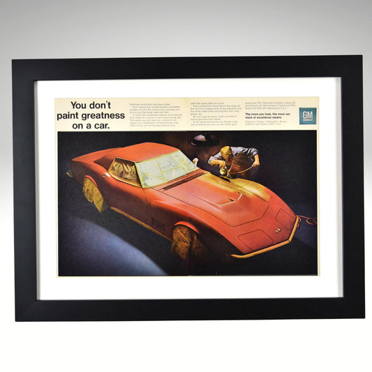Framed 15x20 vintage 1969 GM Corvette two-page print ad showing a Corvette masked with newspaper during paint prep — classic automotive wall art.