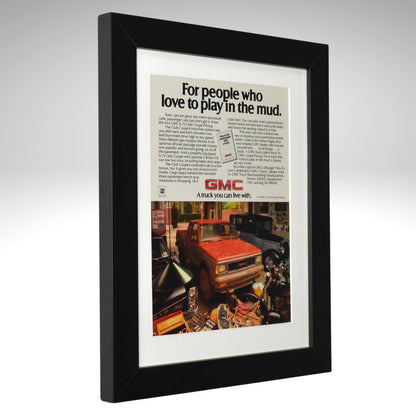 Framed advertisement for GMC truck with text 'For people who love to play in the mud.'