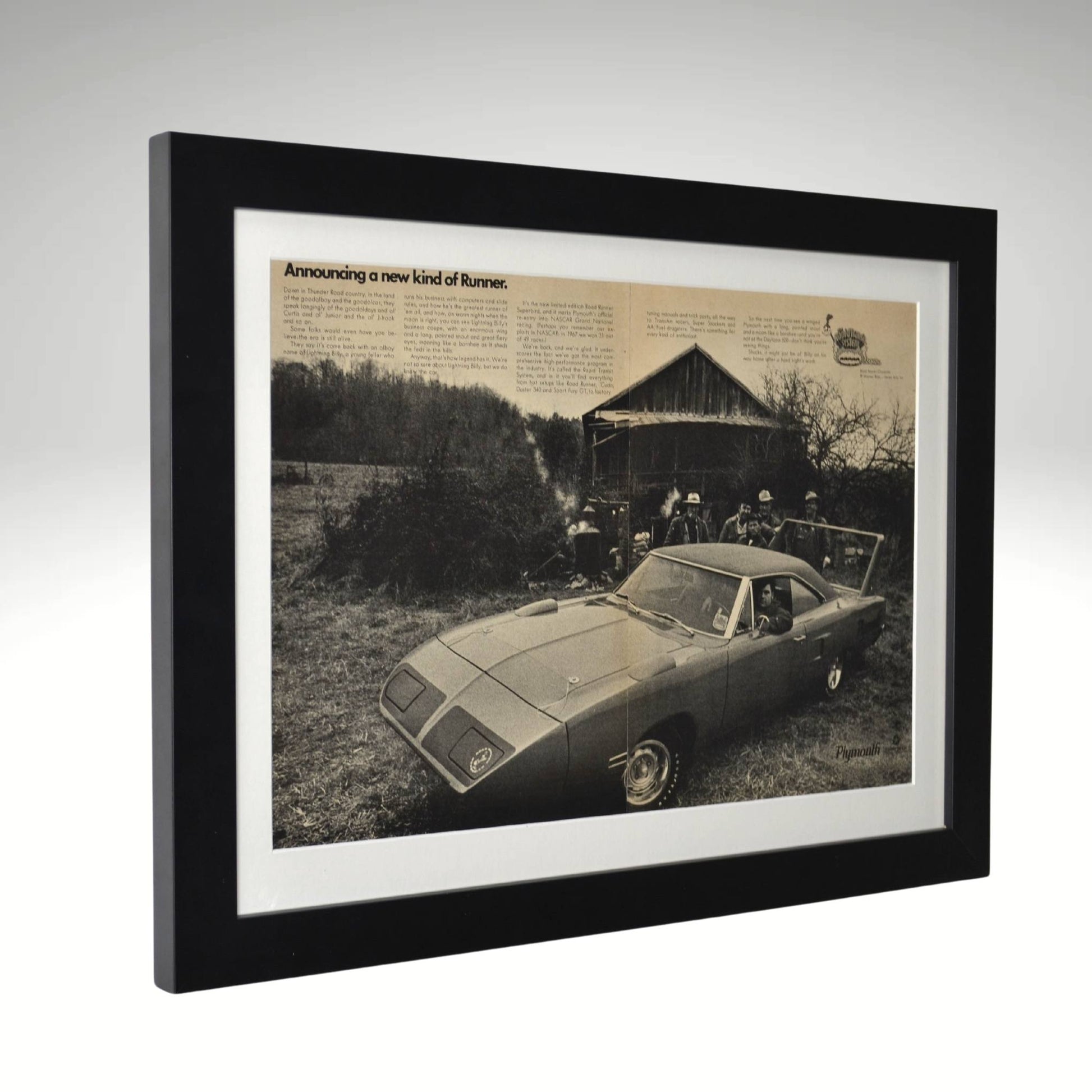 Framed black-and-white print of the 1970 Plymouth Roadrunner Superbird, featuring its aerodynamic design built for NASCAR racing, set against a barn backdrop side view.