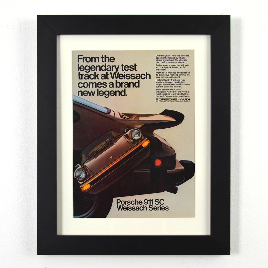 Framed vintage Porsche 911 SC Weissach Series print ad, featuring the limited-edition sports car. Professionally dry mounted and displayed in a 10x13 matte black frame with white matting, ready for wall display.