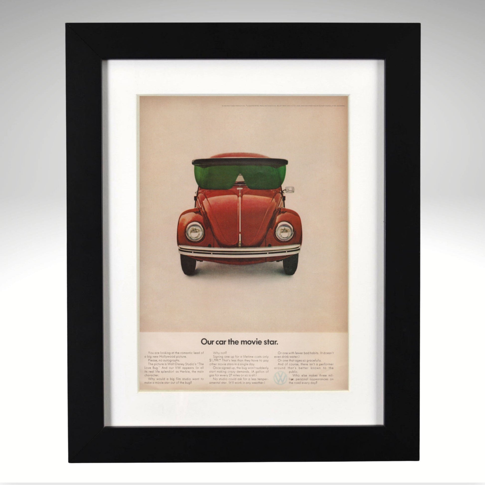 Framed poster of a VW Beetle Disney Movie Star Ad with sunglasses on a beige background