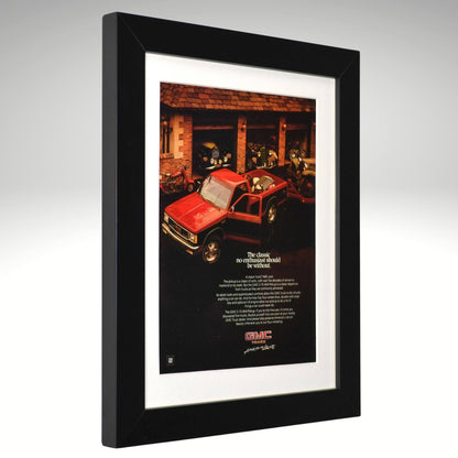 Framed advertisement of a red GMC S-15 pick up truck in a garage setting