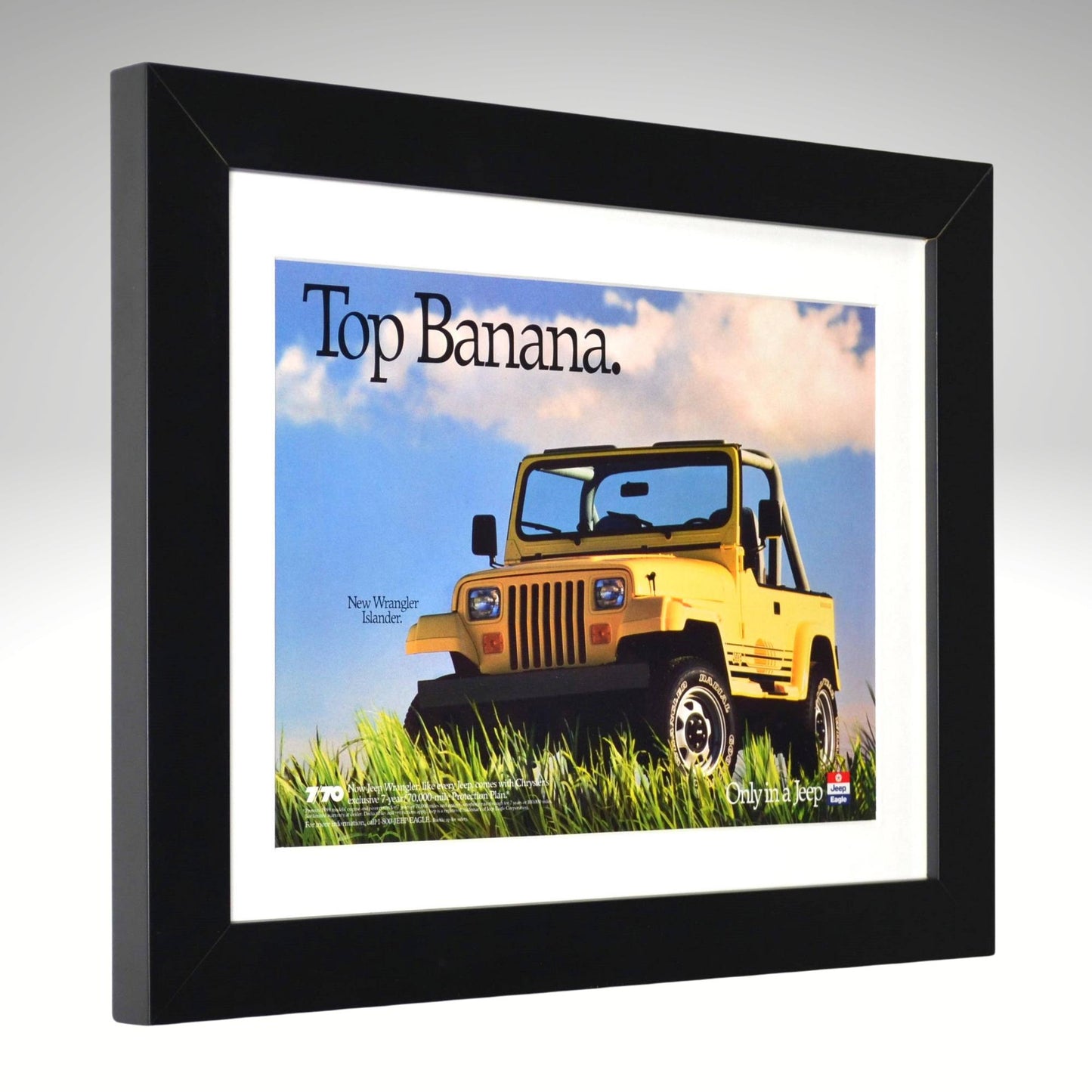 Framed advertisement of a yellow Jeep Wrangler with 'Top Banana' text on a gray background