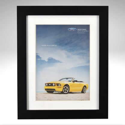 Framed poster of a yellow Ford Mustang convertible against a blue sky with clouds.